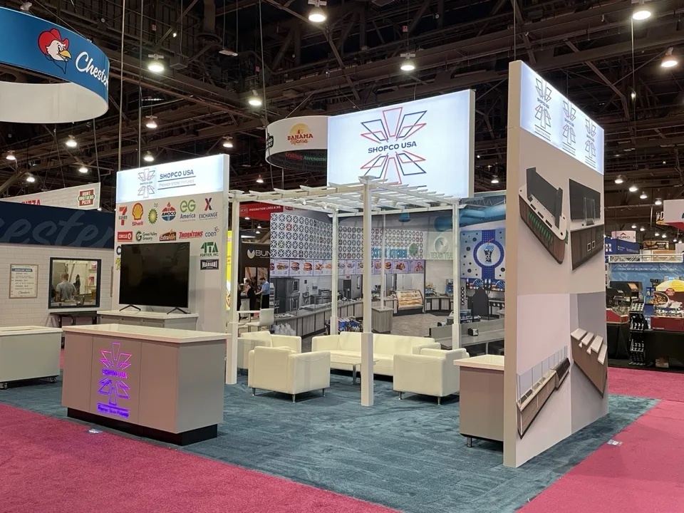 Shopco USA exhibit with illuminated overhead brand architecture