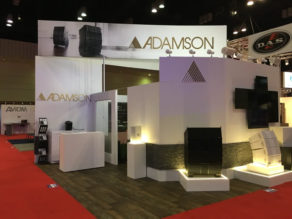Adamson exhibit corner with stone base, product plinths and a mounted display