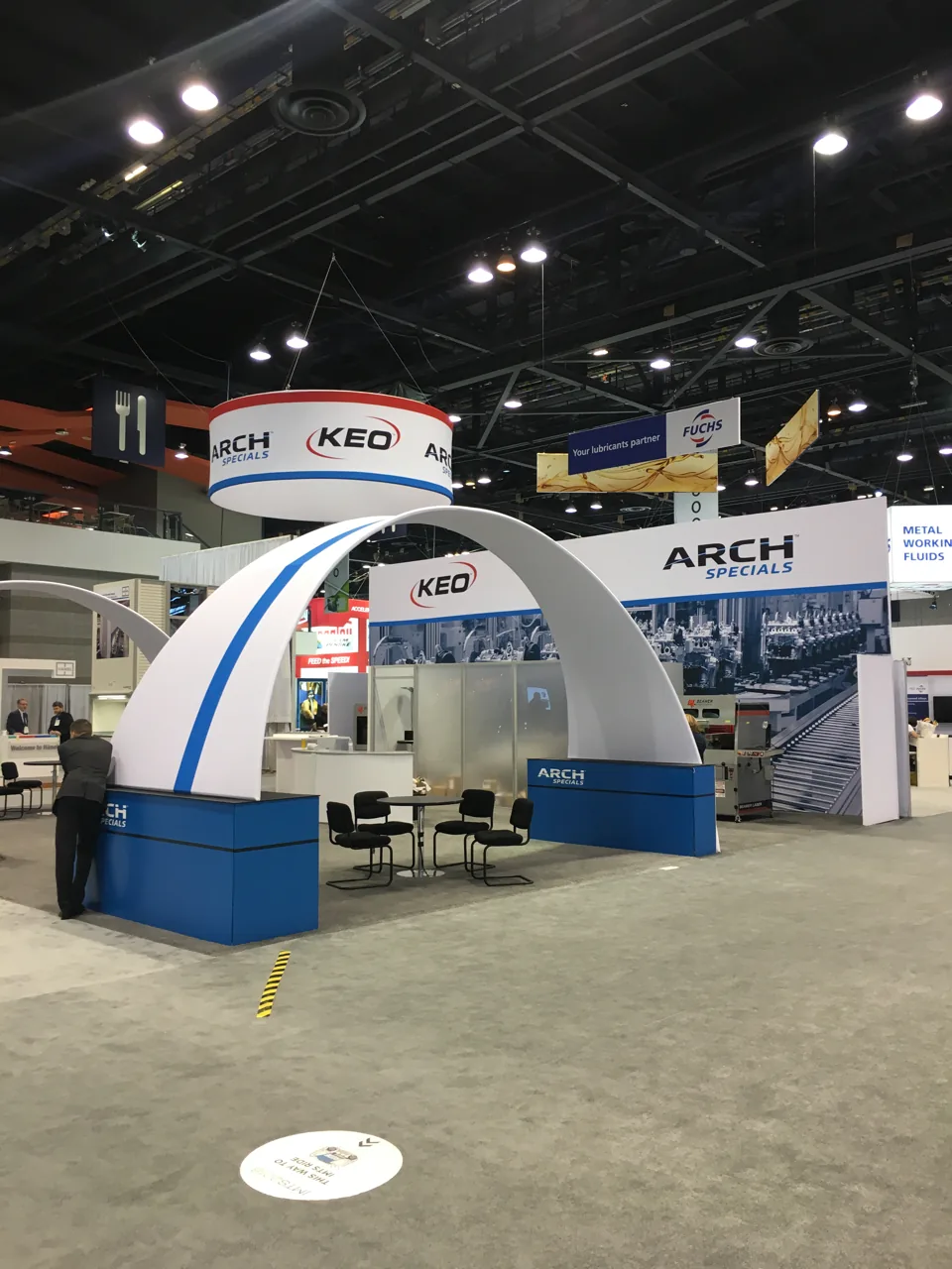 Arch Specials exhibit with a sweeping white arch and blue counter