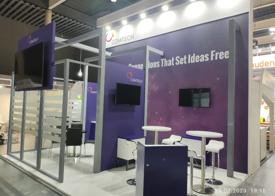Comtech exhibit with purple walls and white bar seating