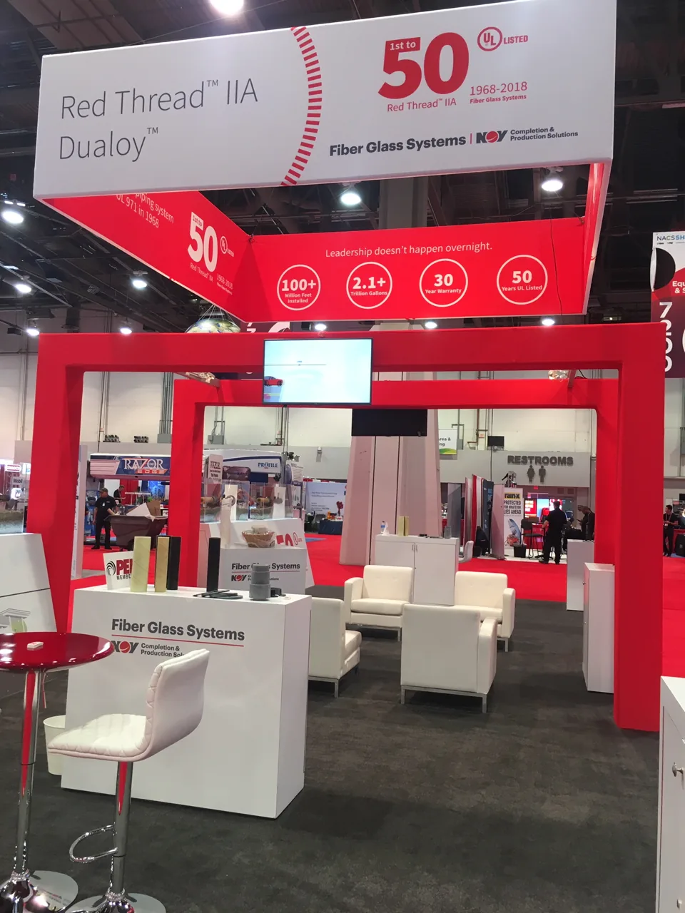 NOV Fiber Glass Systems exhibit with red frame and white overhead sign