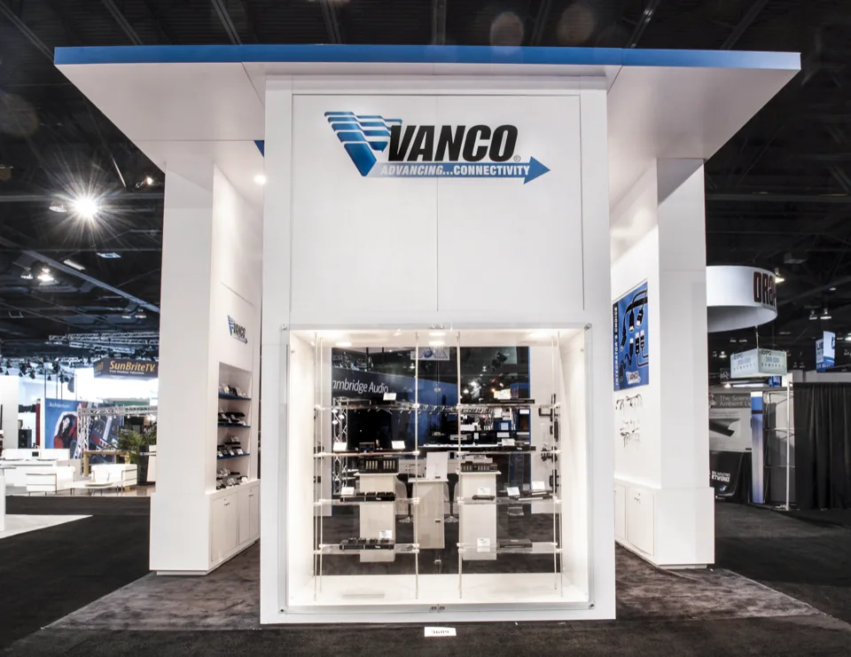 Vanco exhibit with two illuminated white towers and a central brand wall